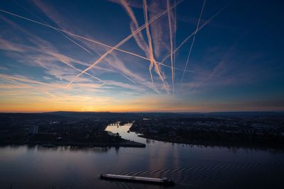 High angle view of river and buildings against sky during sunset