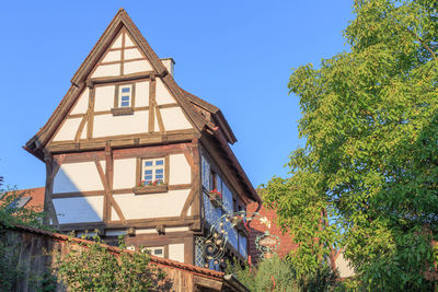 Low angle view of trees and building against sky