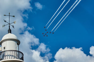 Low angle view of airshow against blue sky