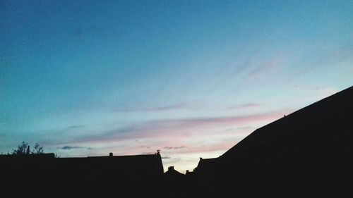 Low angle view of silhouette buildings against sky at dusk