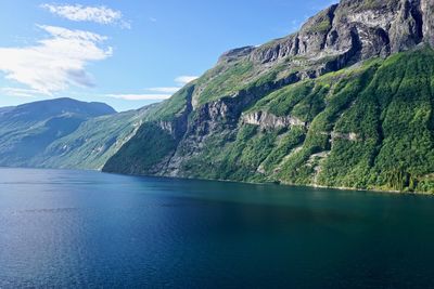 Scenic view of sea and mountains against sky