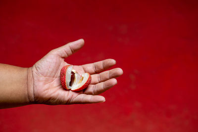 Close-up of human hand against red background