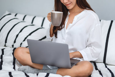 Midsection of woman using laptop