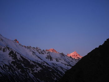 Scenic view of snowcapped mountains against clear blue sky