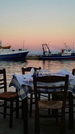 Boats in sea at sunset