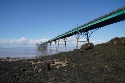 Bridge over land against clear blue sky