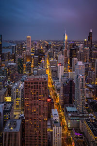 Illuminated cityscape against sky at night