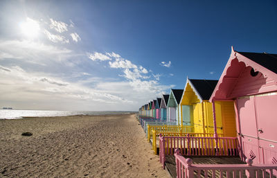 Huts at beach against sky