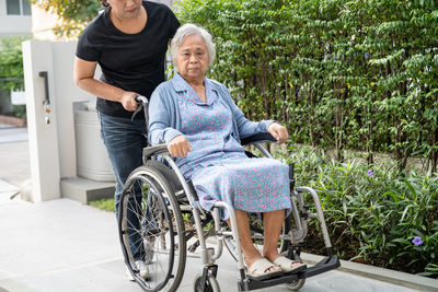 Portrait of woman sitting on wheelchair
