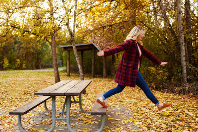 Woman with umbrella in park during autumn