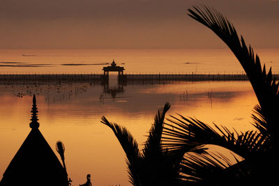 Scenic view of gazebo over sea during sunset