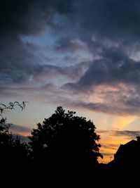 Low angle view of silhouette trees against sky