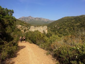 People walking on mountain against sky