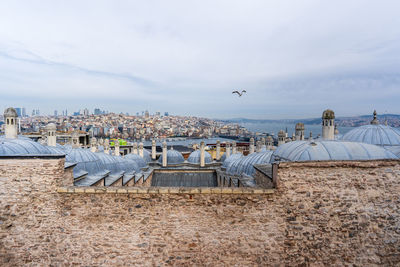 Houses by sea against sky