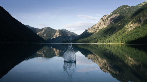 Scenic view of lake by mountains against sky