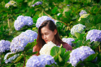 Smiling woman by flowering plants