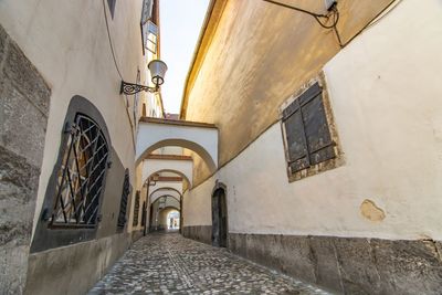 Low angle view of empty alley amidst buildings