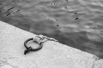 High angle view of mooring chains tied on pier against sea