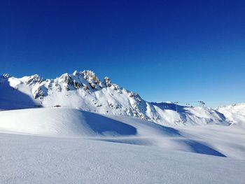 Snowcapped mountains against clear blue sky