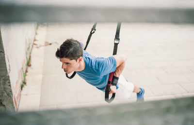 Young man exercising on building terrace