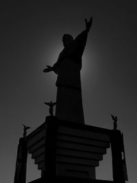 Low angle view of silhouette statue against sky