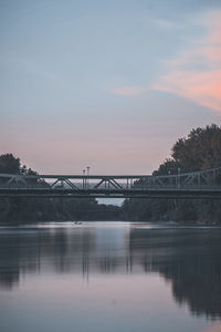 Bridge over river against sky during sunset