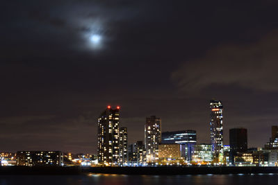 Illuminated cityscape against sky at night