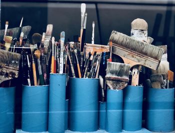 Close-up of paintbrushes in containers
