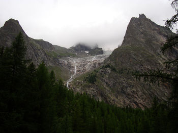 Scenic view of rocky mountains against sky during foggy weather