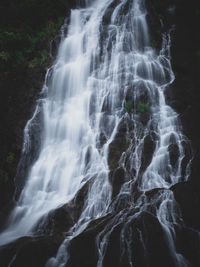 Epic waterfall close up. flowing stream with black rock cliff. long exposure. sarika fall, thailand.