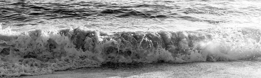 Panoramic view of sea waves splashing on shore