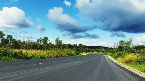 Road amidst trees against sky