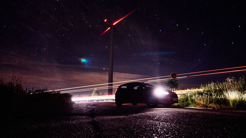 Light trails on road against sky at night