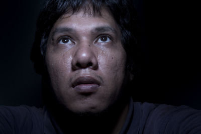 Portrait of young man over black background