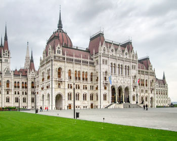 Buildings in city against cloudy sky