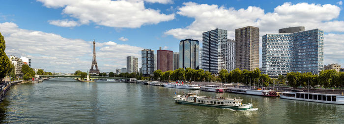 Panoramic view of river and buildings against sky in city