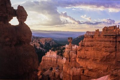 Rock formations against cloudy sky