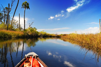 Canoe in river against cloudy sky