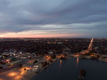 High angle view of illuminated buildings in city at sunset