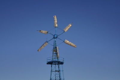 Low angle view of communications tower against clear blue sky