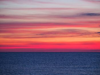 Scenic view of sea against romantic sky at sunset