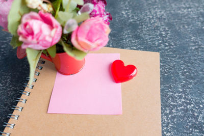 Heart shape with book and flowers on table