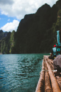 Person sitting on wooden raft at sea