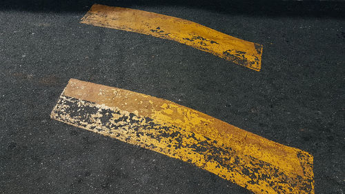 Close-up of yellow arrow symbol on road