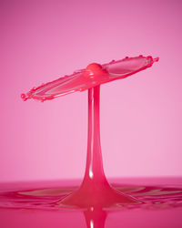 Close-up of red splashing water against white background