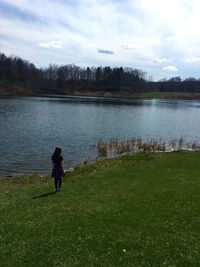 Rear view of man on lake against sky