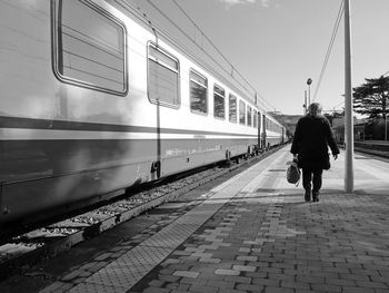 Rear view of people walking on railroad station platform