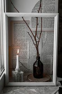 Close-up of electric lamp on table by window at home