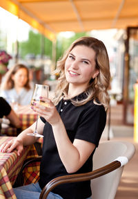 Smiling young woman sitting in restaurant at cafe