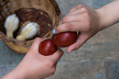 Holding and cracking red easter eggs